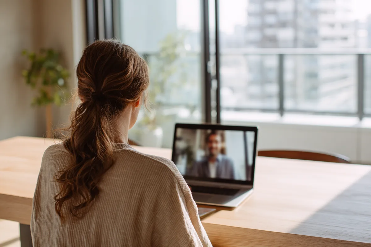 A woman in a live one-to-one video language lesson at home